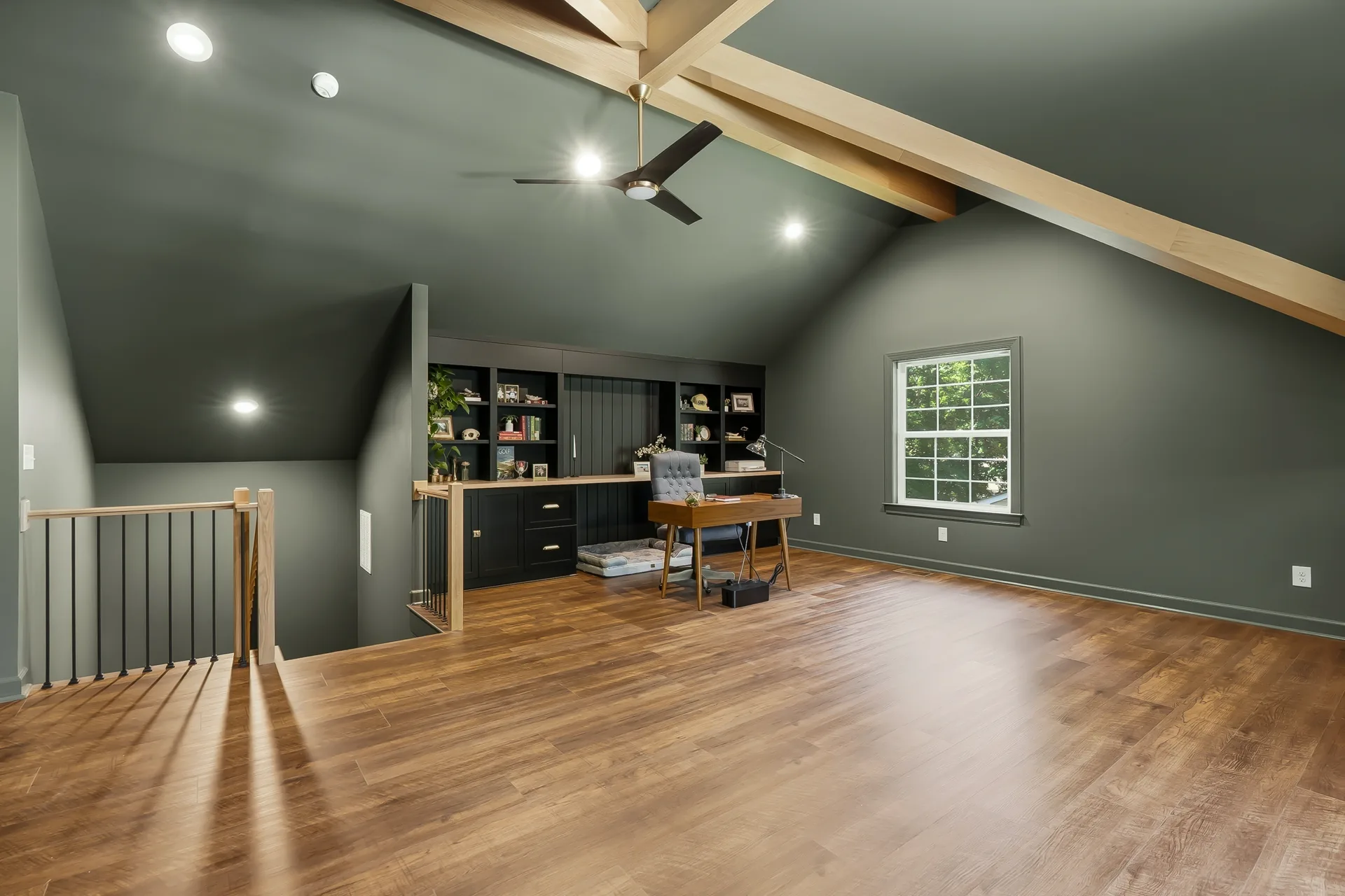 Finished attic home office with vaulted ceiling, wood beams, and built-in desk